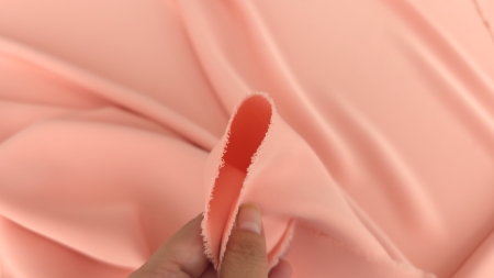Margine prinsă între degete, cu față și revers mate în nuanță peach