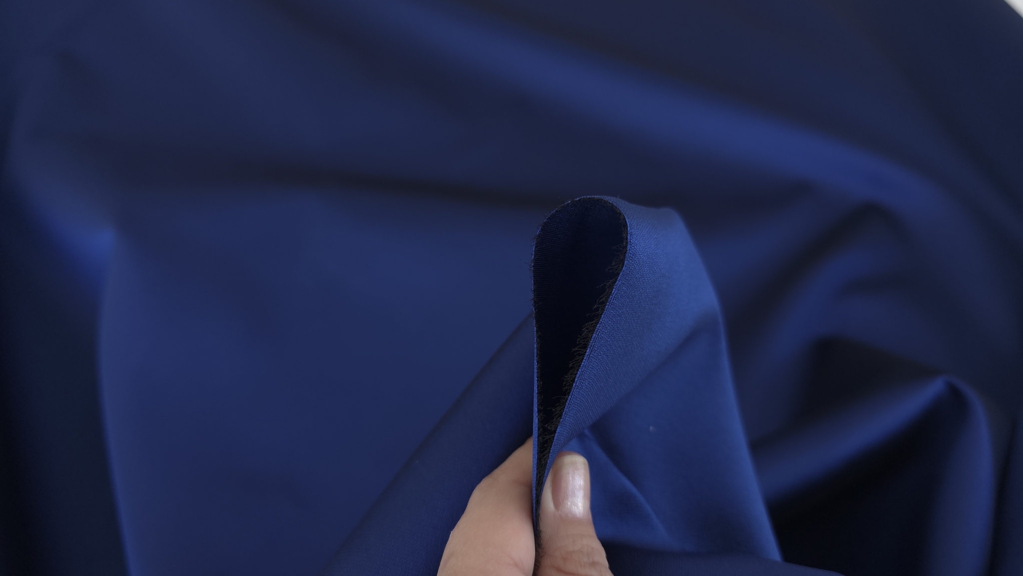 Mână strânge țesătură mikado albastru indigo pentru ținute de gală, falduri neregulate și corp ferm vizibil