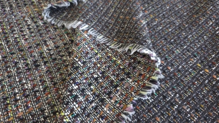 Colț întors cu margine franjurată al unei țesături multicolore