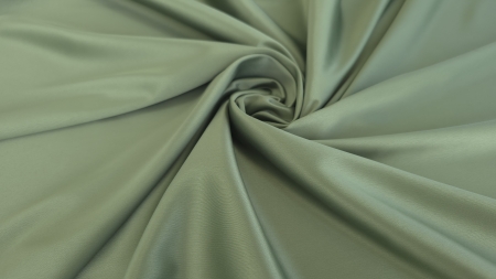 Material verde maslin răsucit în spirală cu falduri strânse spre centru și ton uniform