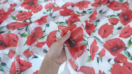 metraj voal chiffon mătase naturală maci roșii fond alb ținut în mână