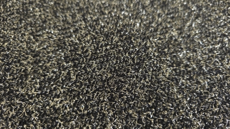 Detaliu de textură neagră cu fire metalice fine și reflexe cromate
