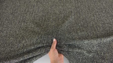 Țesătură neagră cu fir cromat ținută în mână, cu reflexe metalice fine pe suprafață