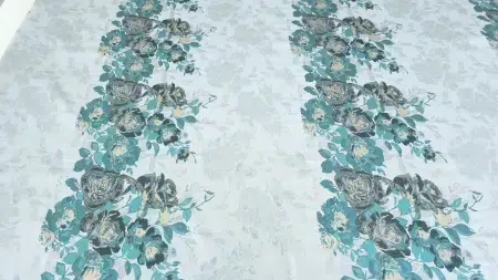Brocard metalizat floral aqua gold întins pe masă, cu buchete turcoaz pe fond deschis