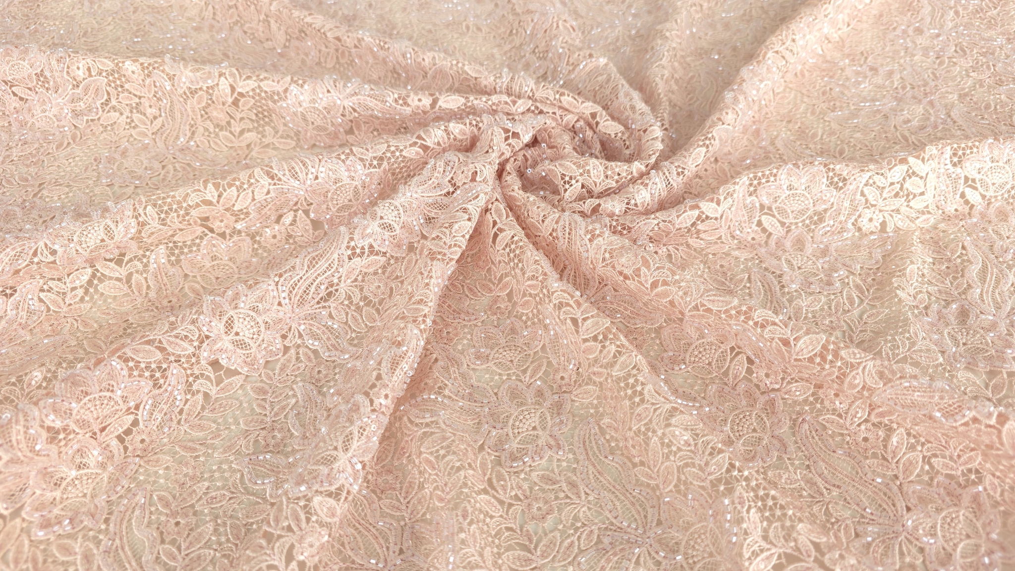 Material brodat roz pastel la metru cu motive florale dense pe fond de tul