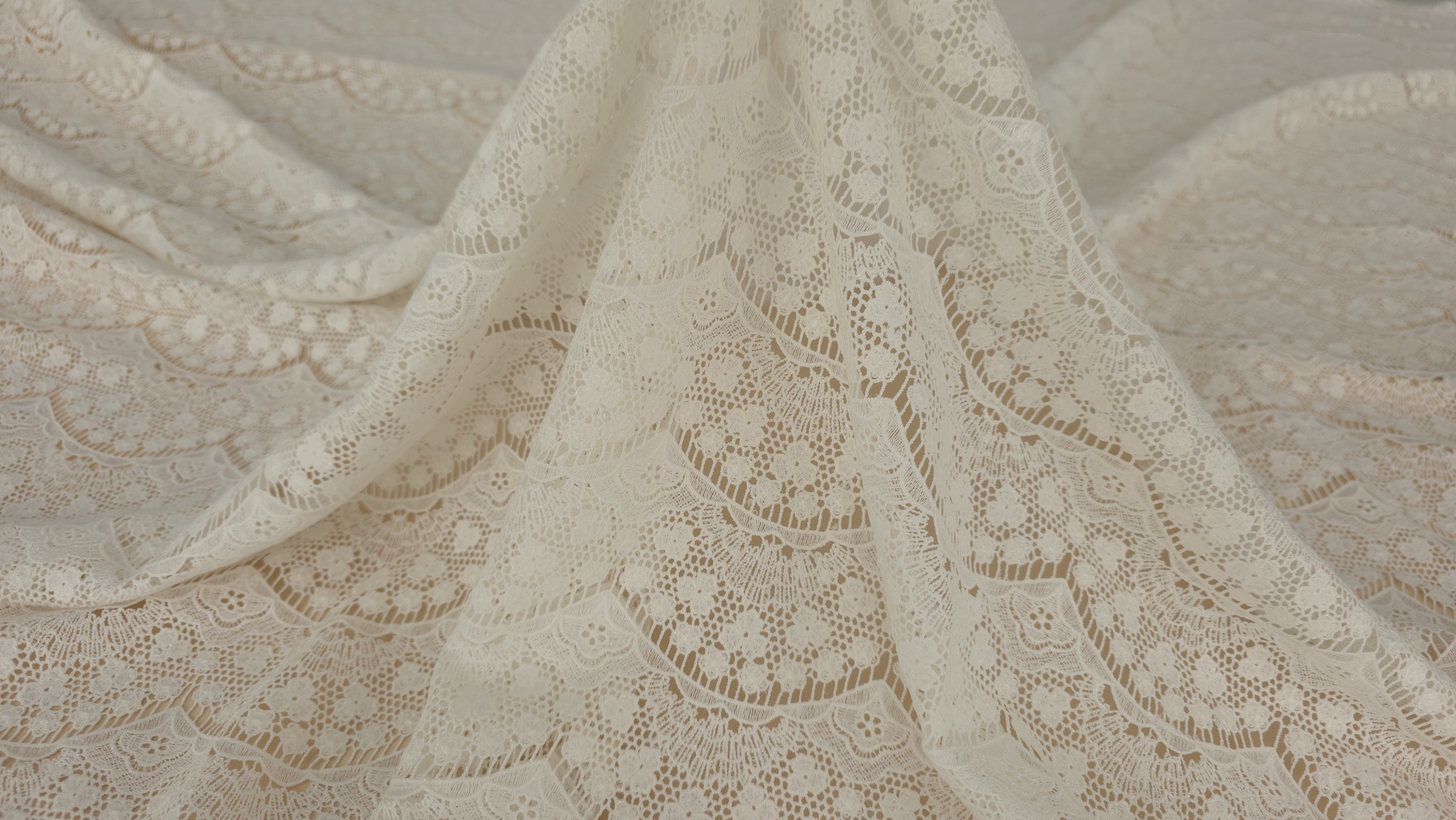 Bordura scalopata cu gene fine pe marginea materialului ivory suspendat