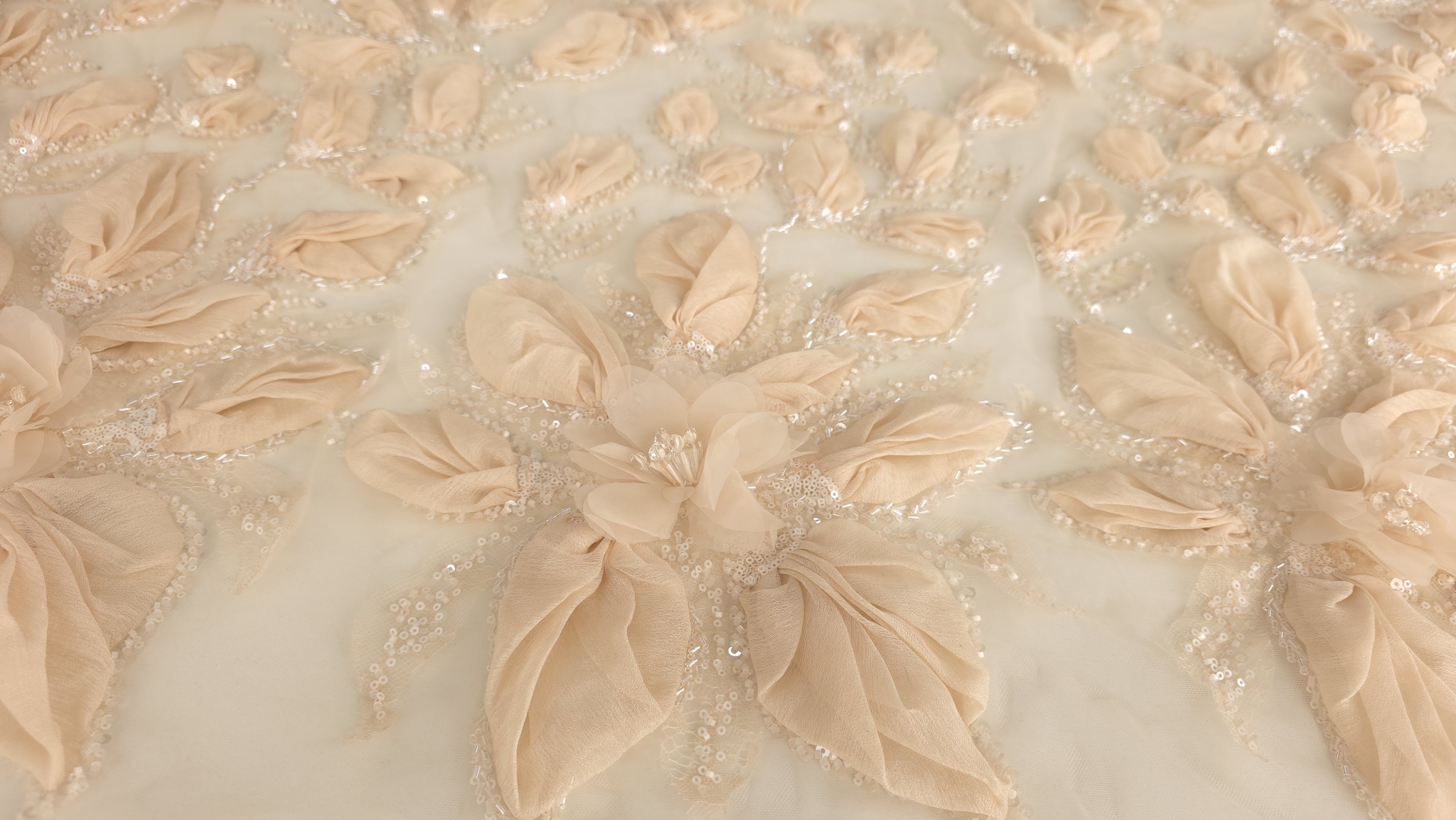 Broderie 3D peach cu flori dense și paiete transparente, textură vizibilă în plan larg