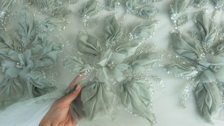 Broderie verde cu flori voluminoase din organza, evidențiind contrastul cu tulul albb