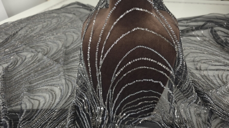 Broderie argintie pe tul negru ridicat pe manechin, model curbat în formă de frunză cu mărgele și paiete