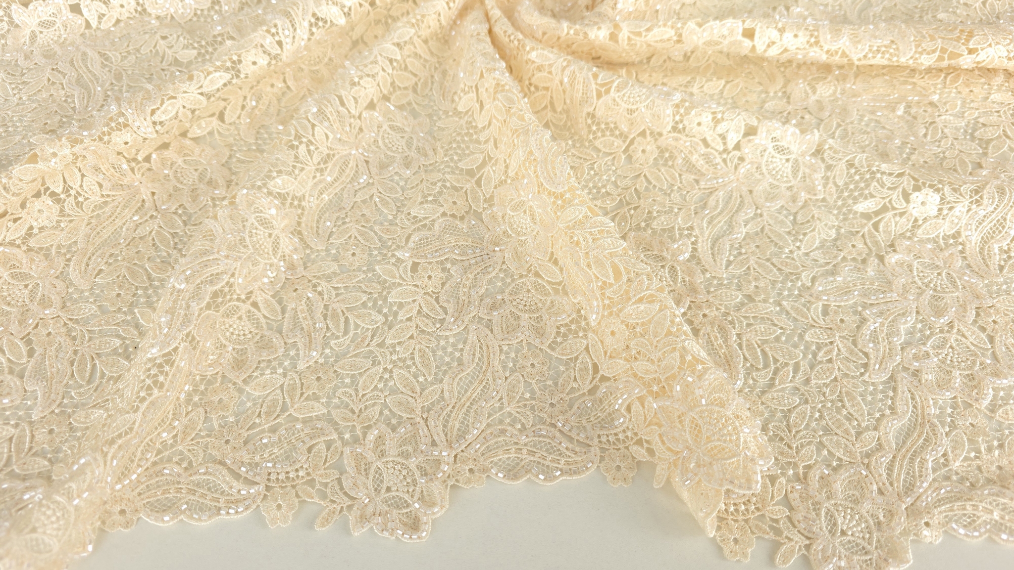 Broderie florală champagne accesorizată formând falduri cu reflexii calde