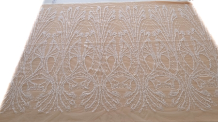Broderie ivory pe tull nude întinsă pe masă vedere de ansamblu cu motiv repetat pe toată lățimea