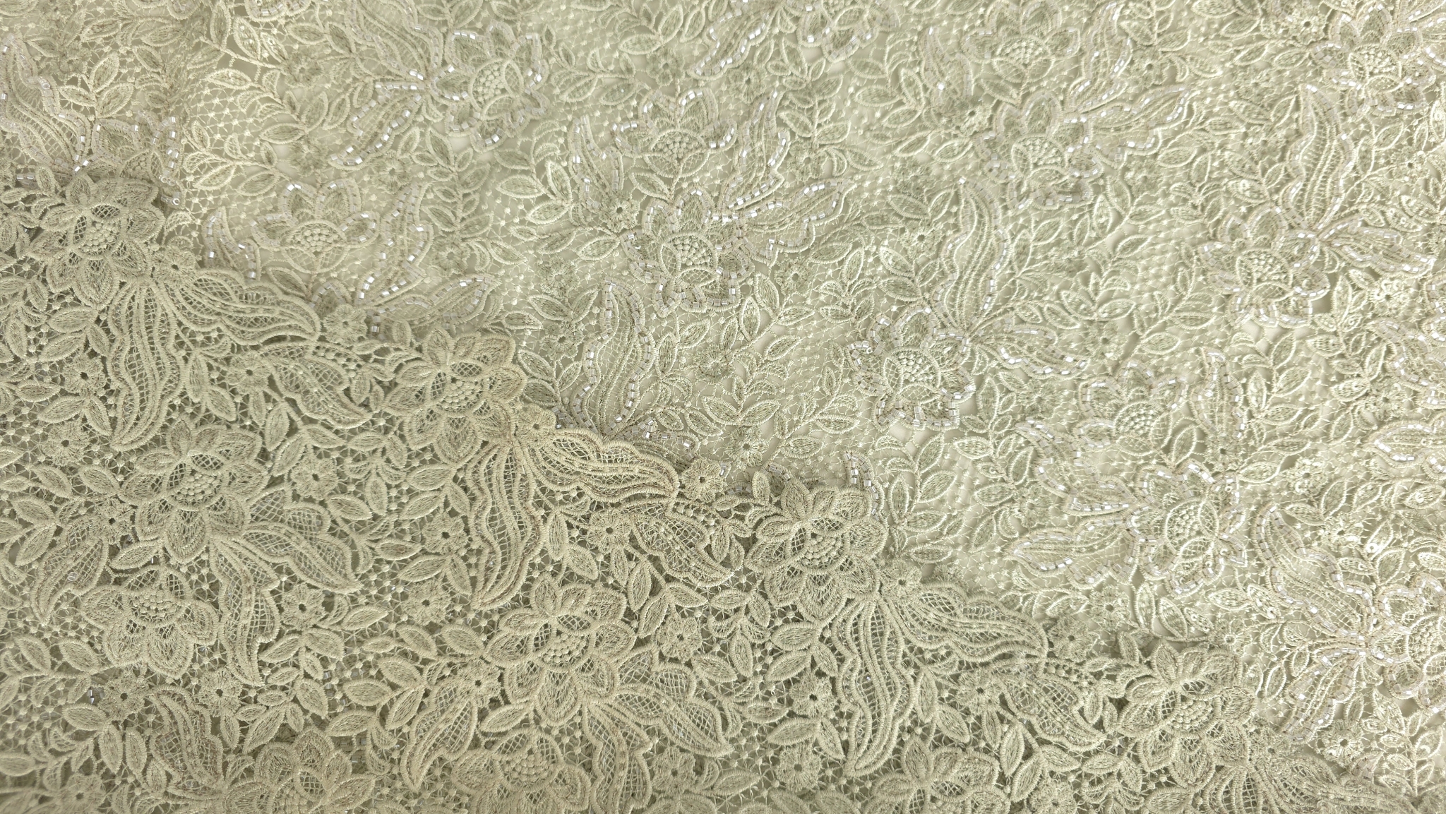 Broderie olive cu margele tubulare prezentată panoramic pe suprafață plană