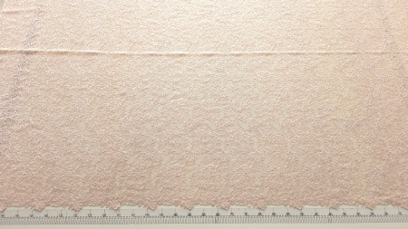 Metraj brodat roz cu aplicații decorative desfăcut pe masă de tăiere