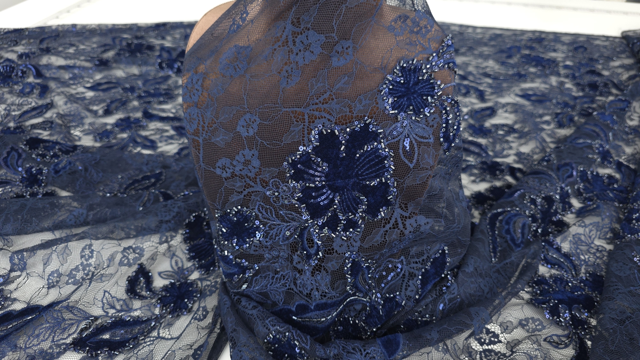 Bust cu material bleumarin transparent, floare din catifea cu margele tubulare în prim plan