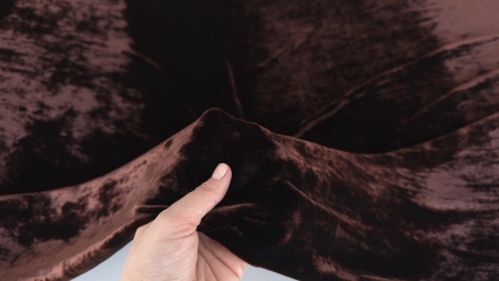 Catifea chocolate brown din mătase naturală atinsă cu degetul în plan apropiat