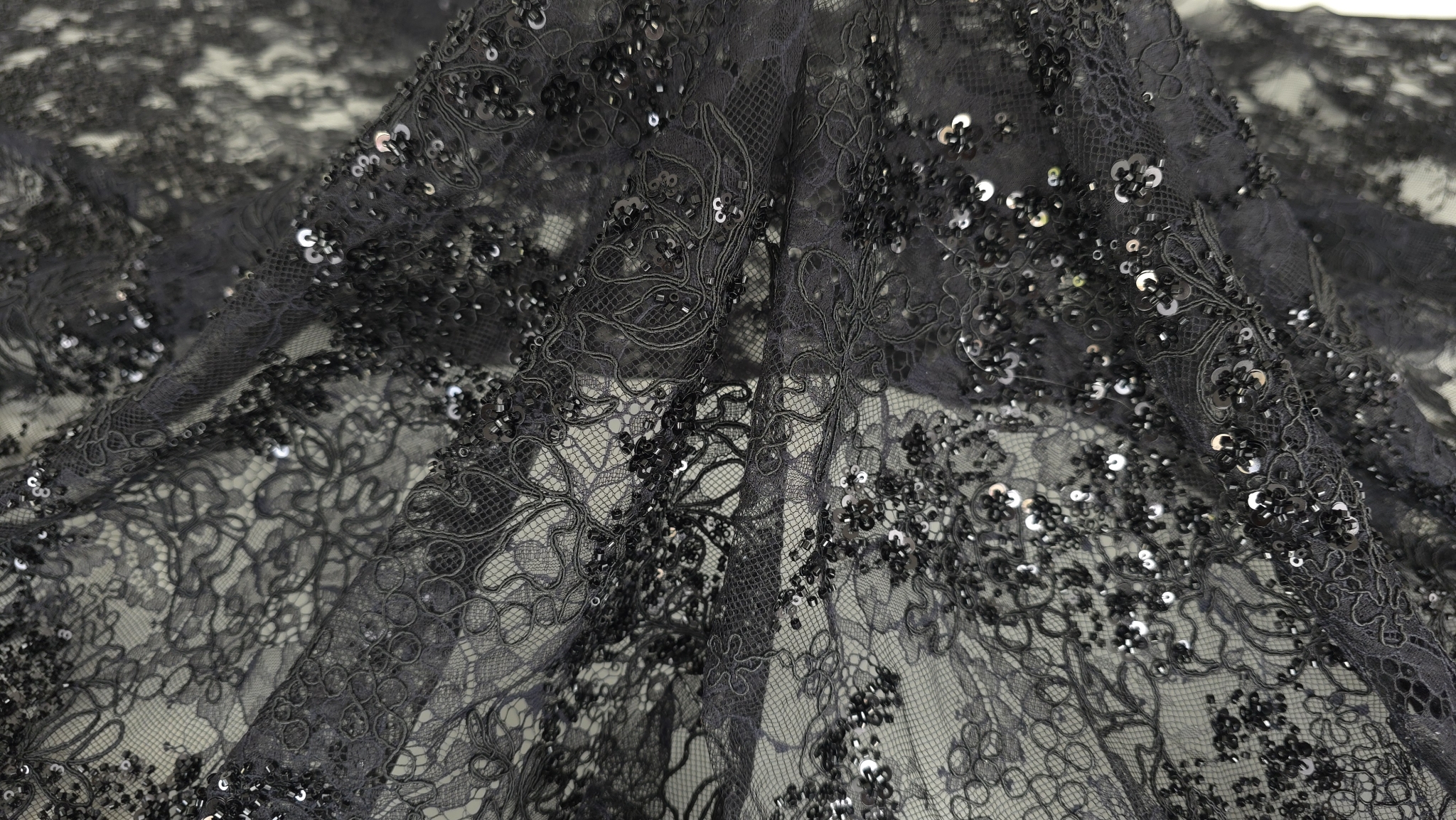 Colțul materialului evidențiind finisajul scallop și densitatea rebroderiei