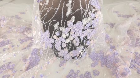 Contrast vizual al broderiei lila prezentată pe un manechin de culoare închisă