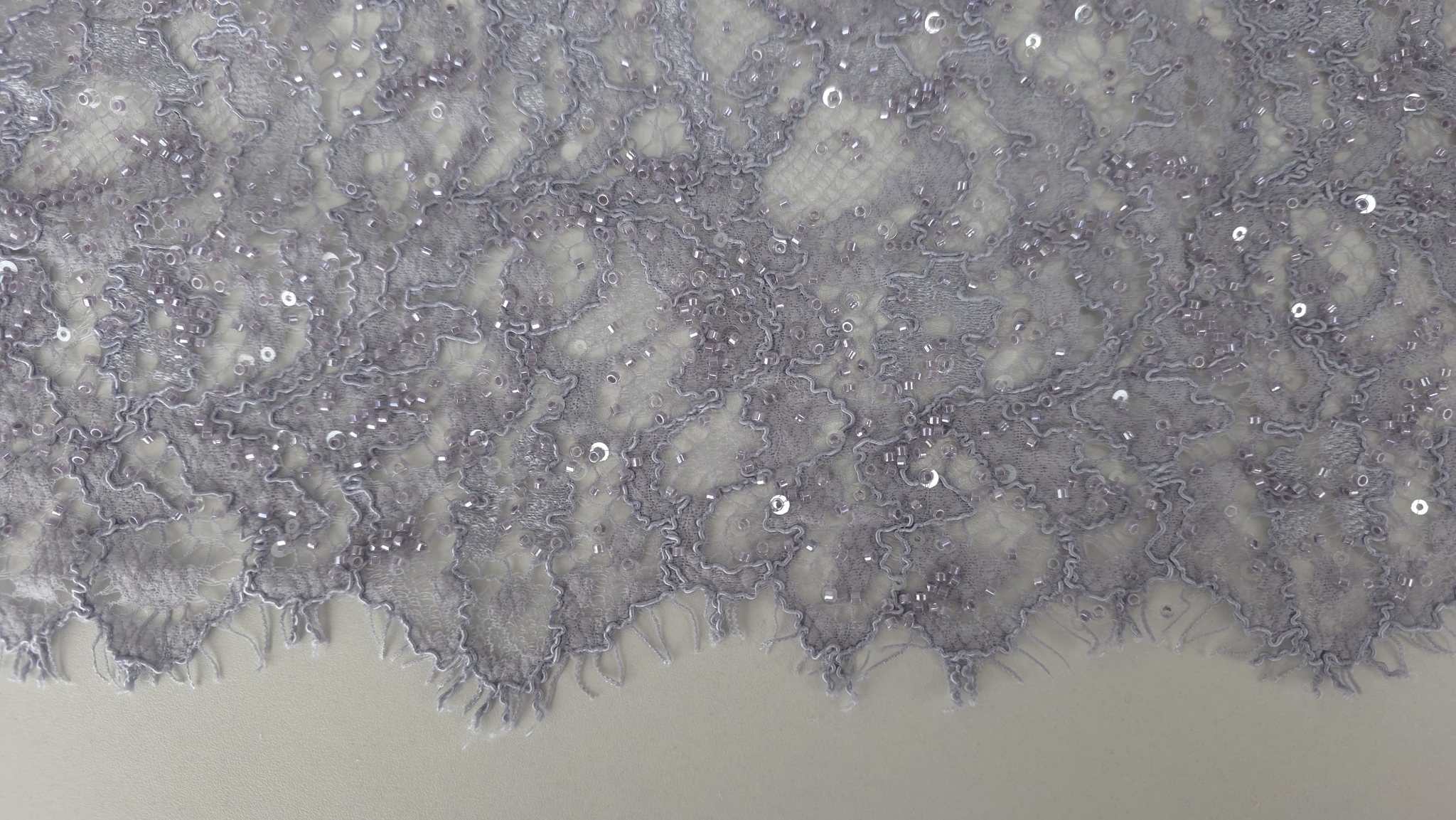 Contur scalopat cu gene fine pe marginea materialului, plan apropiat