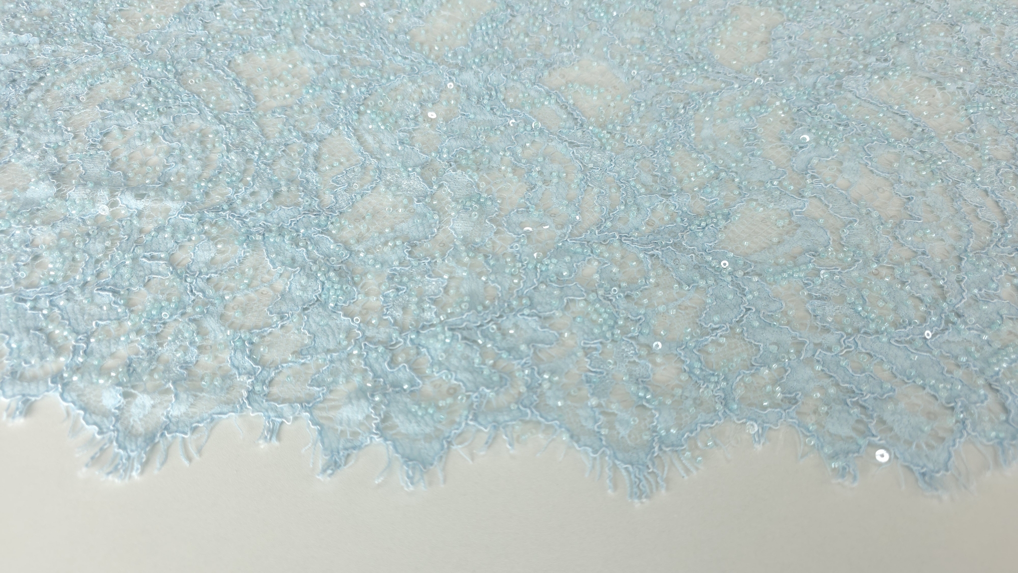 Dantelă accesorizată albastru deschis, plan apropiat pe conturul scalopat cu gene fine