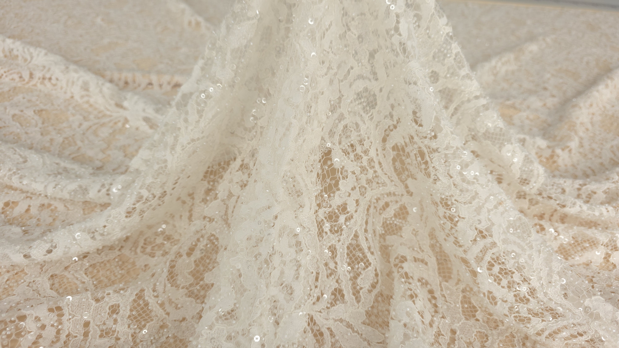 Dantelă ivory ținută în mână pentru vizualizarea transparenței tului