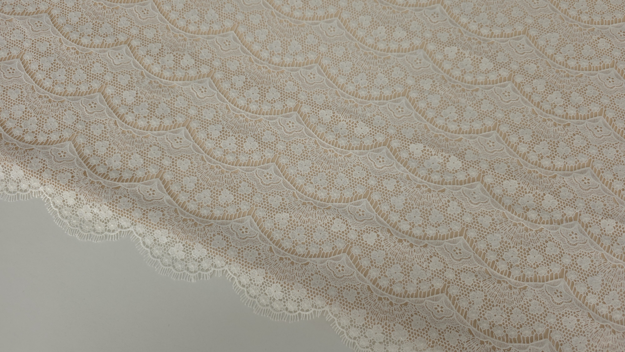 Dantela macrame ivory cu model floral repetitiv pe manechin, vedere frontala cu bordura scalopata la tiv