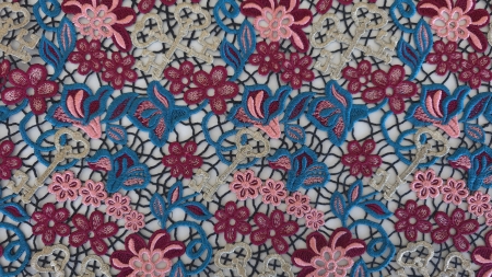 Dantelă multicoloră cu fir strălucitor în falduri evidențiind culorile fucsia