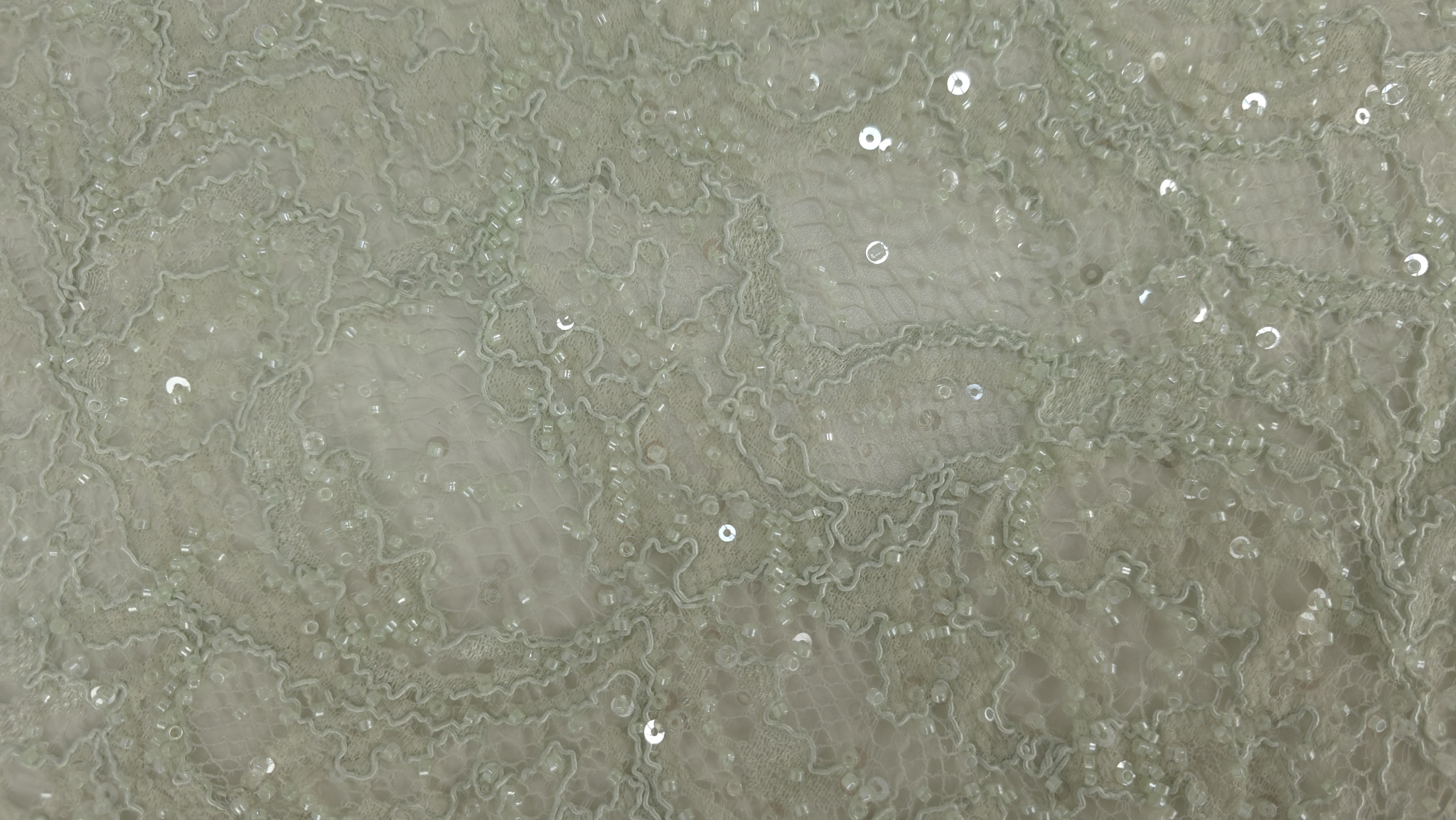 Dantelă verde pastel cu paiete, detaliu pe zona brodată cu gene la margine