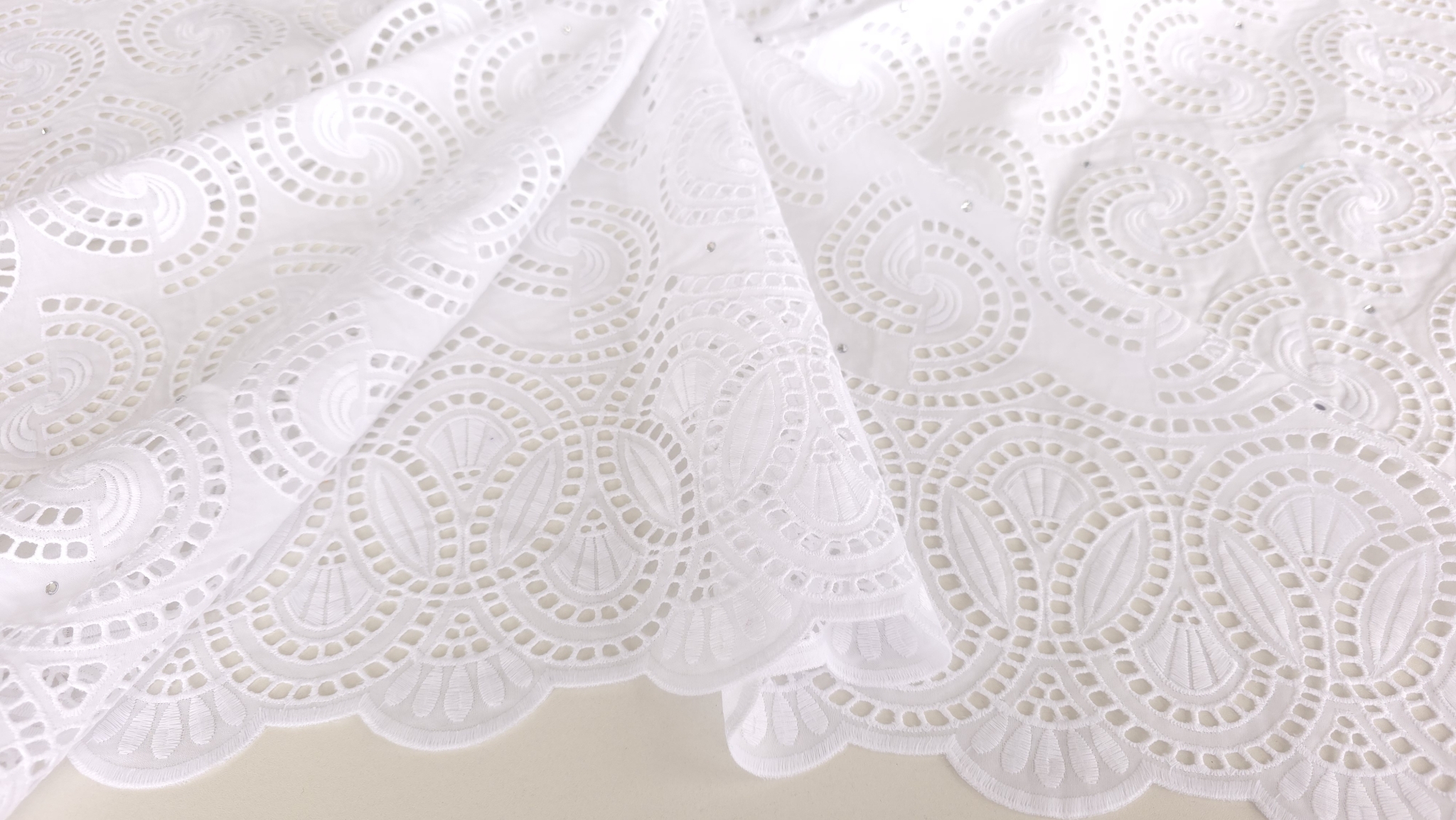 Detaliu macro al bordurii scalop cu motive ovale și perforații pe dantelă din bumbac alb