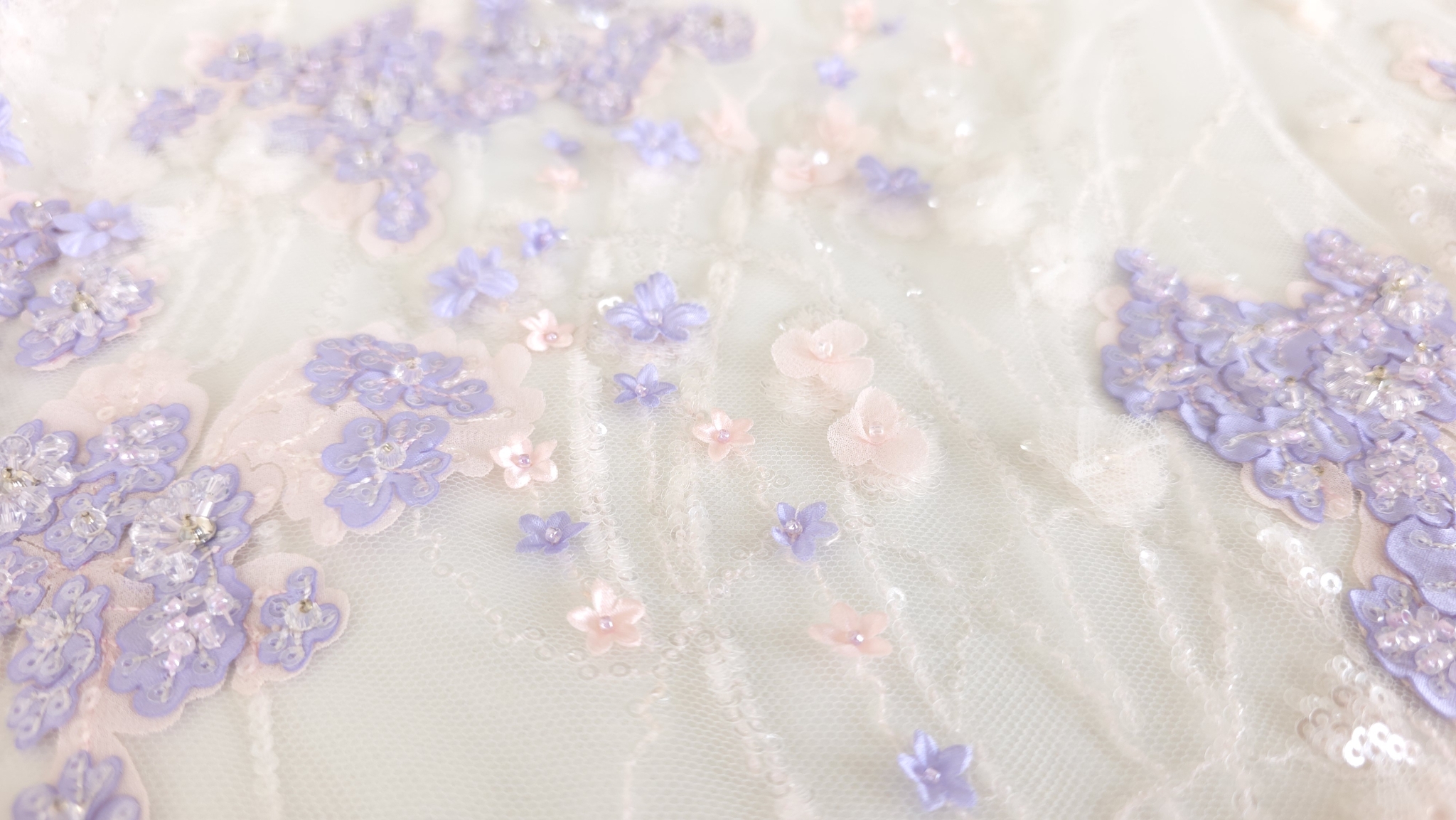 Detaliu macro cu floricele individuale mici fixate între fire brodate cu paiete