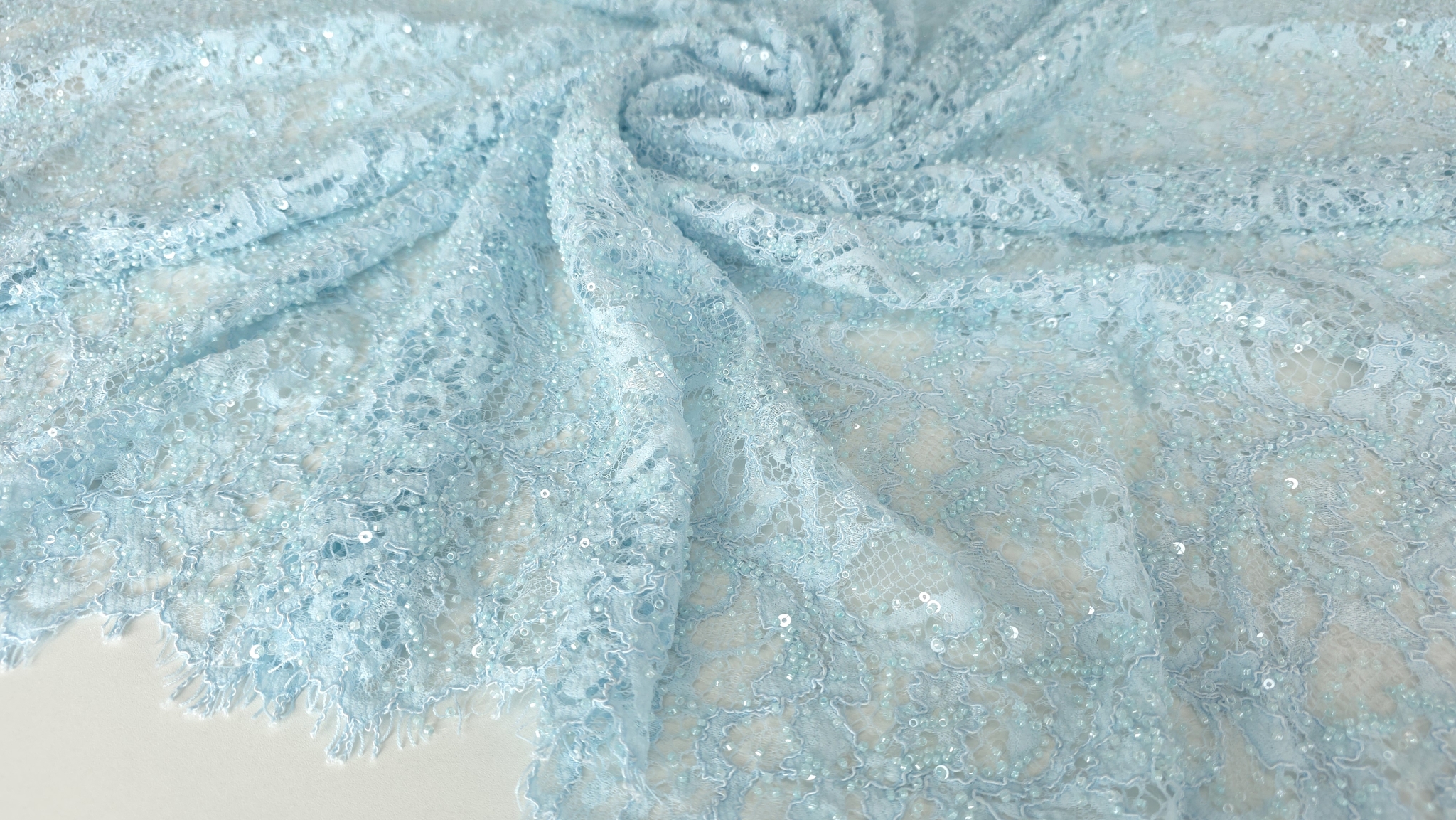 Detaliu macro pe broderia florală cu aplicații lucioase distribuite dens