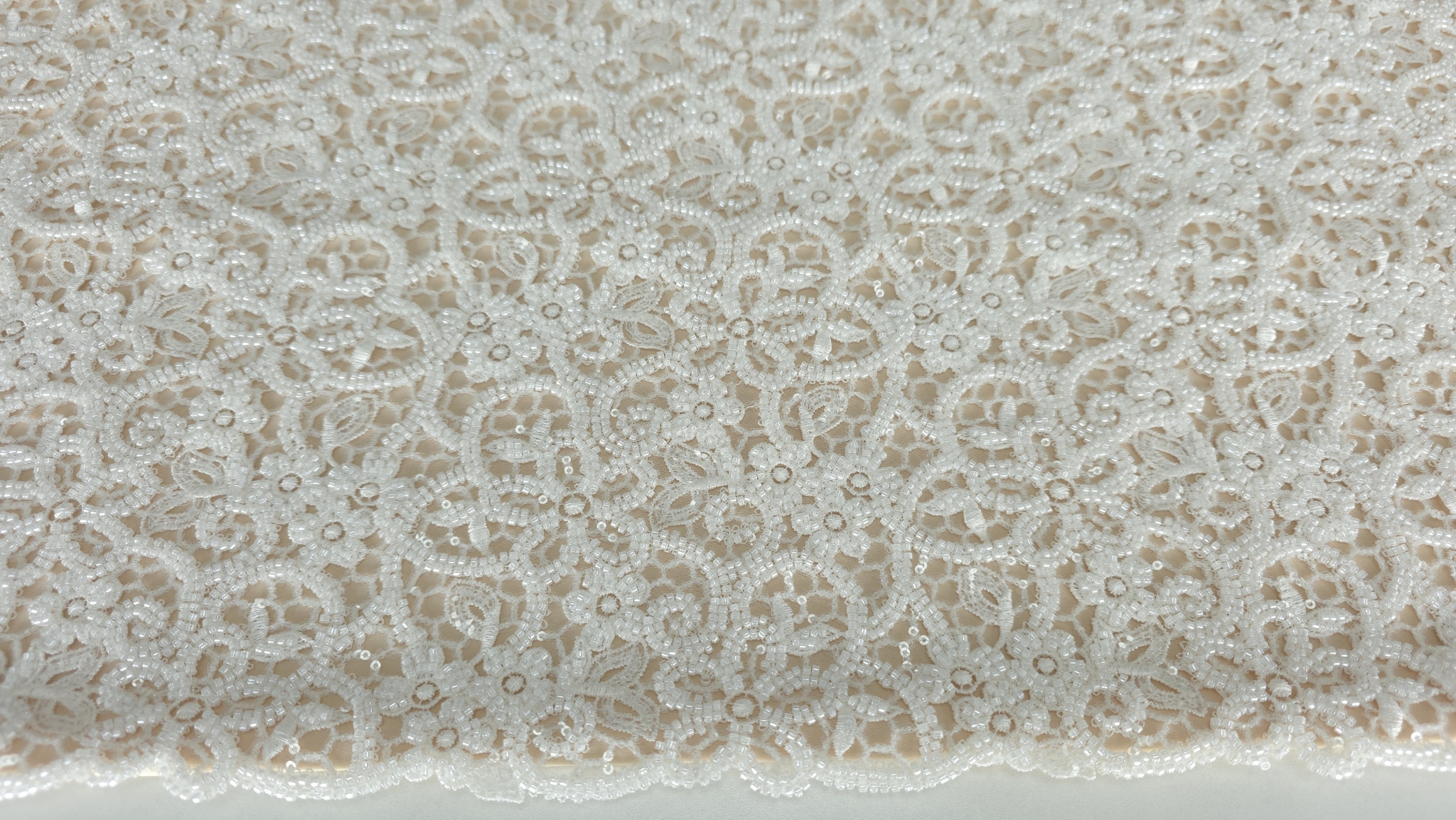 Detaliu macro pe motive florale ivory cu elemente sferice cusute