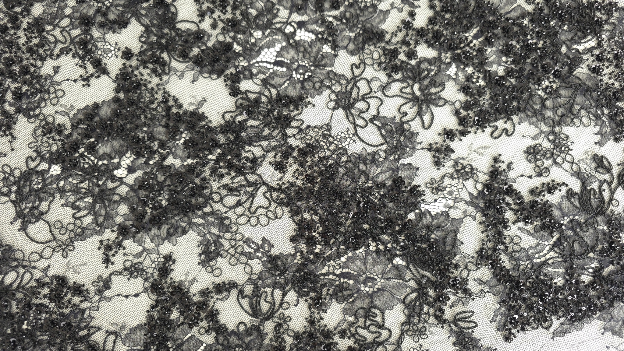 Detaliu macro pe motive florale rebrodare cu margele și paiete vizibile