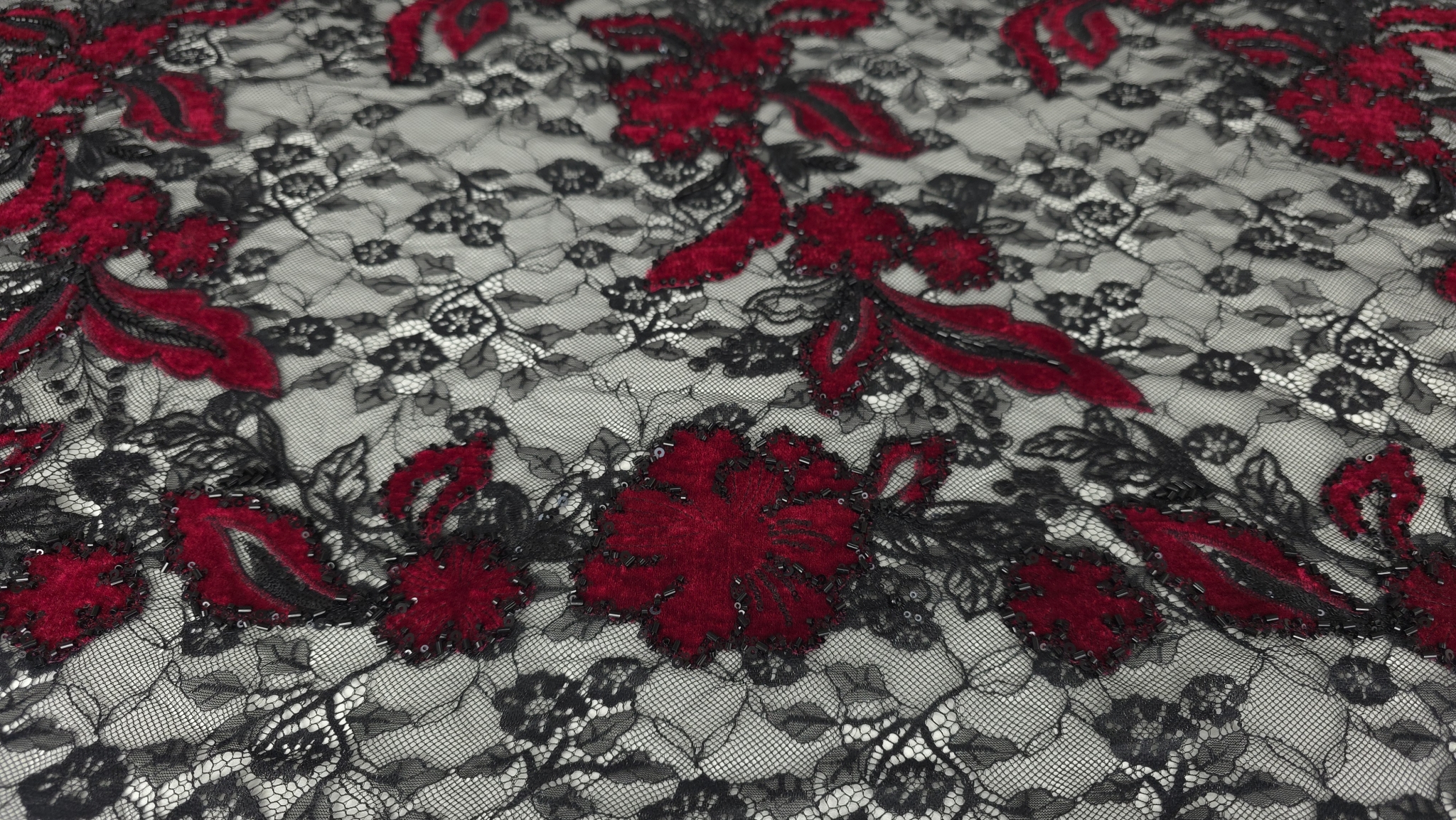 Detaliu margele tubulare și micropaiete negre pe conturul motivelor florale din catifea