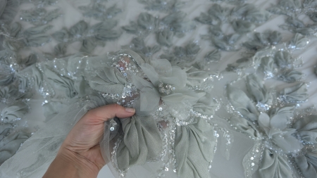 Organza sidefată verde pliată în petale pe fond textil alb