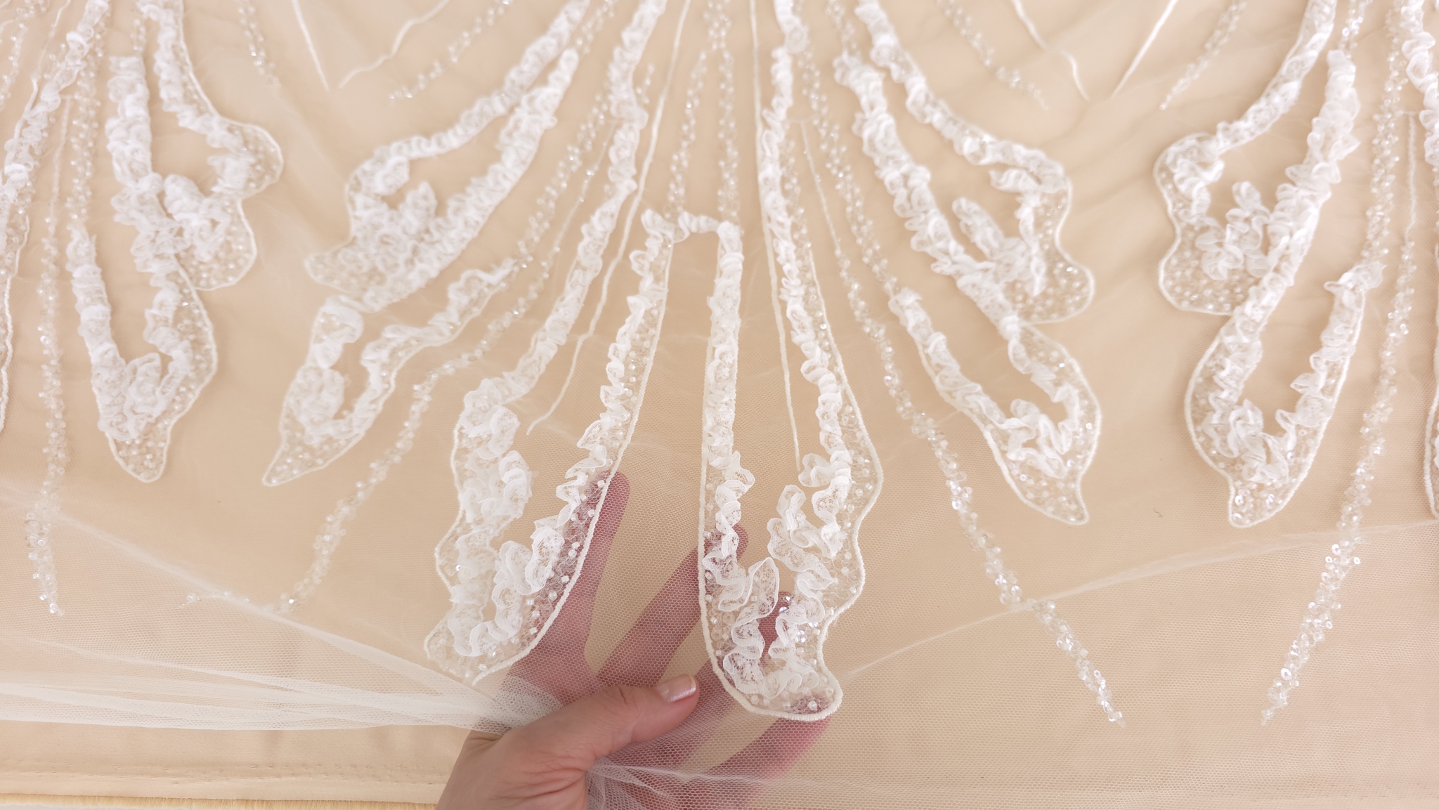 Detaliu relief al broderiei atins cu degetul margele și dantelă ondulată vizibile