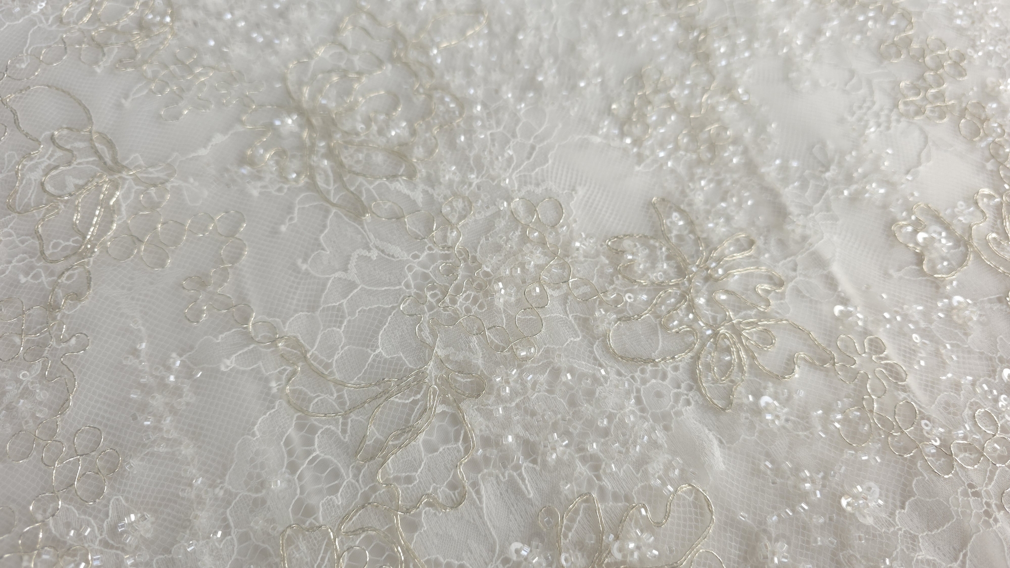 Elemente sferice mici cusute manual pe țesătură florală deschisă