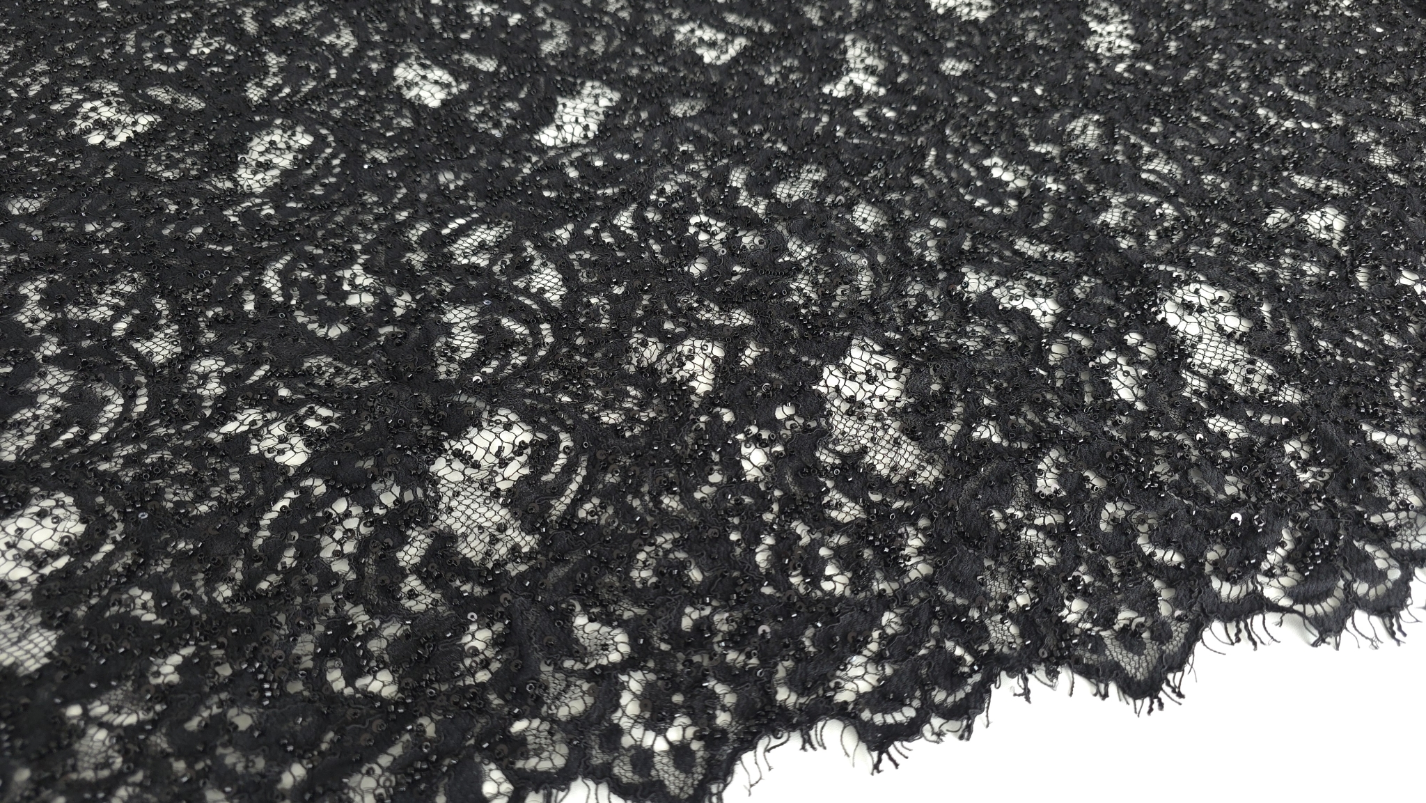 Falduri ample de material închis la culoare cu puncte de strălucire distribuite