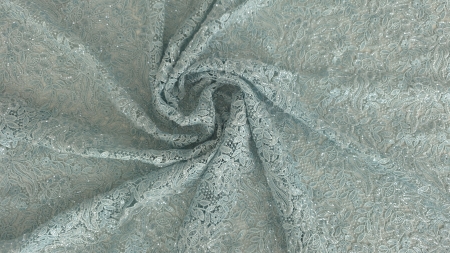 Falduri de material pastel formând o spirală pe suprafață plană