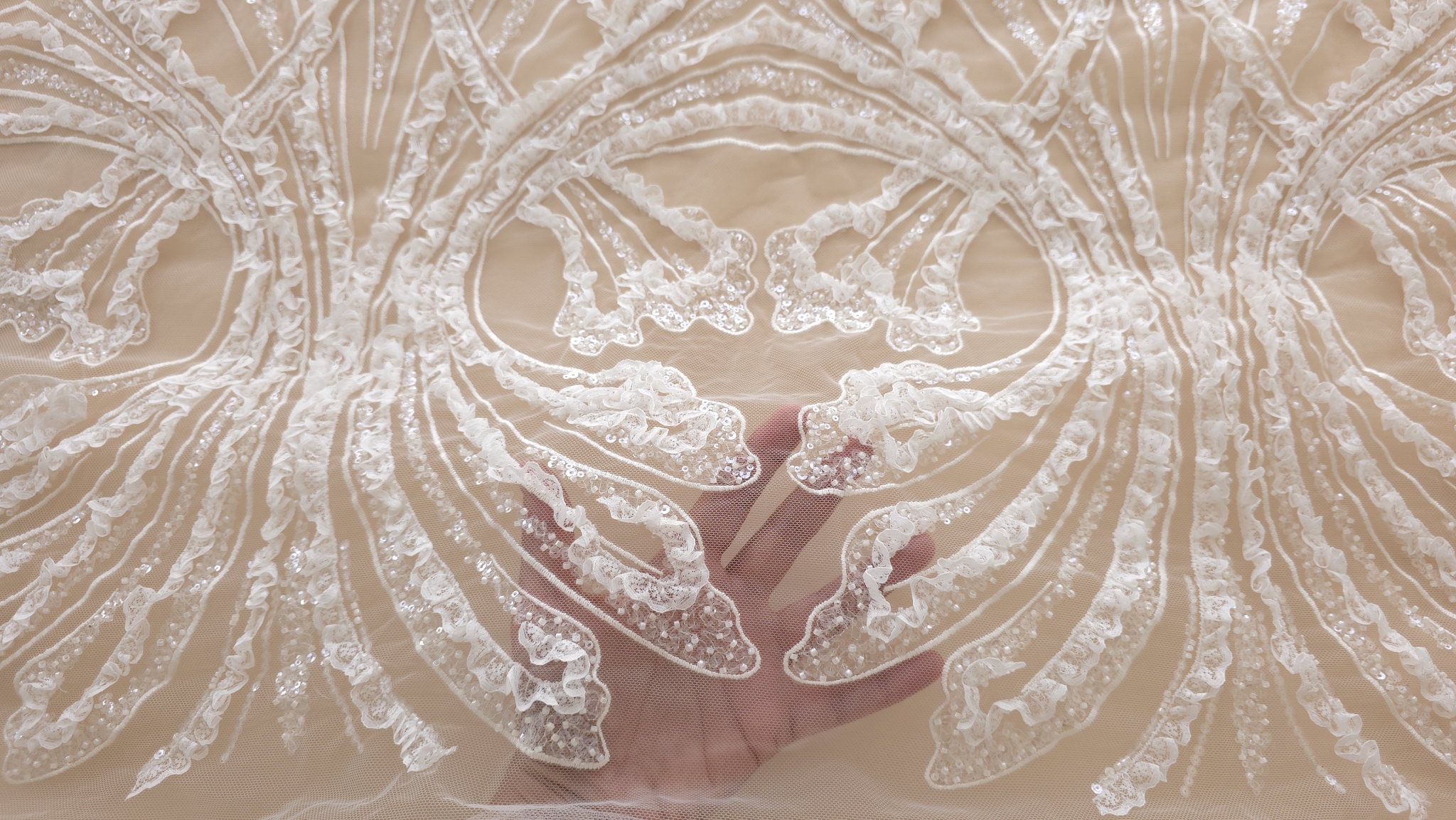 Falduri de tull transparent cu volănașe ivory, micropaiete și margele în plan apropiat