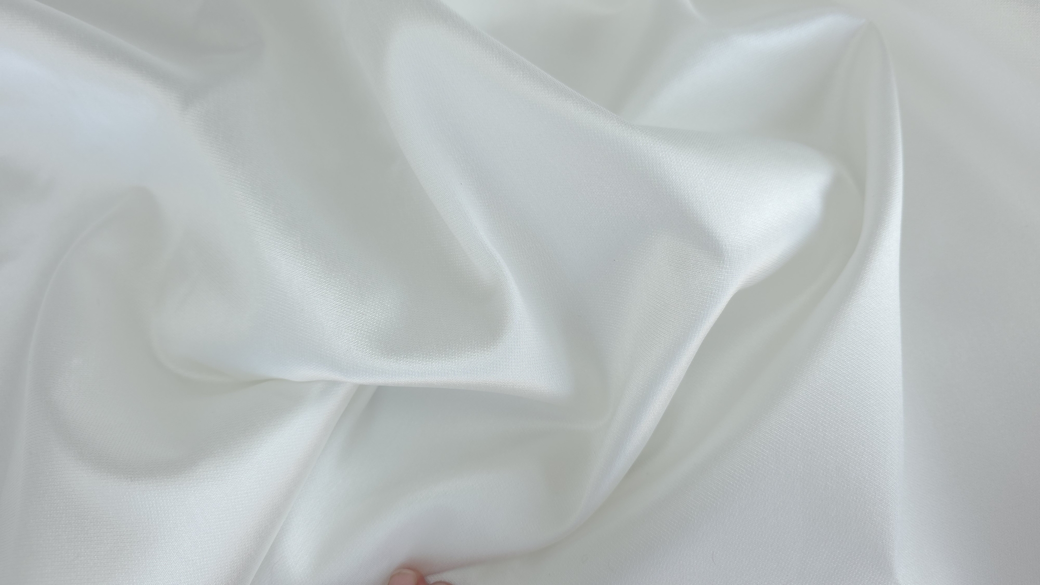 Falduri largi cu reflexii de lumină pe țesătură ivory