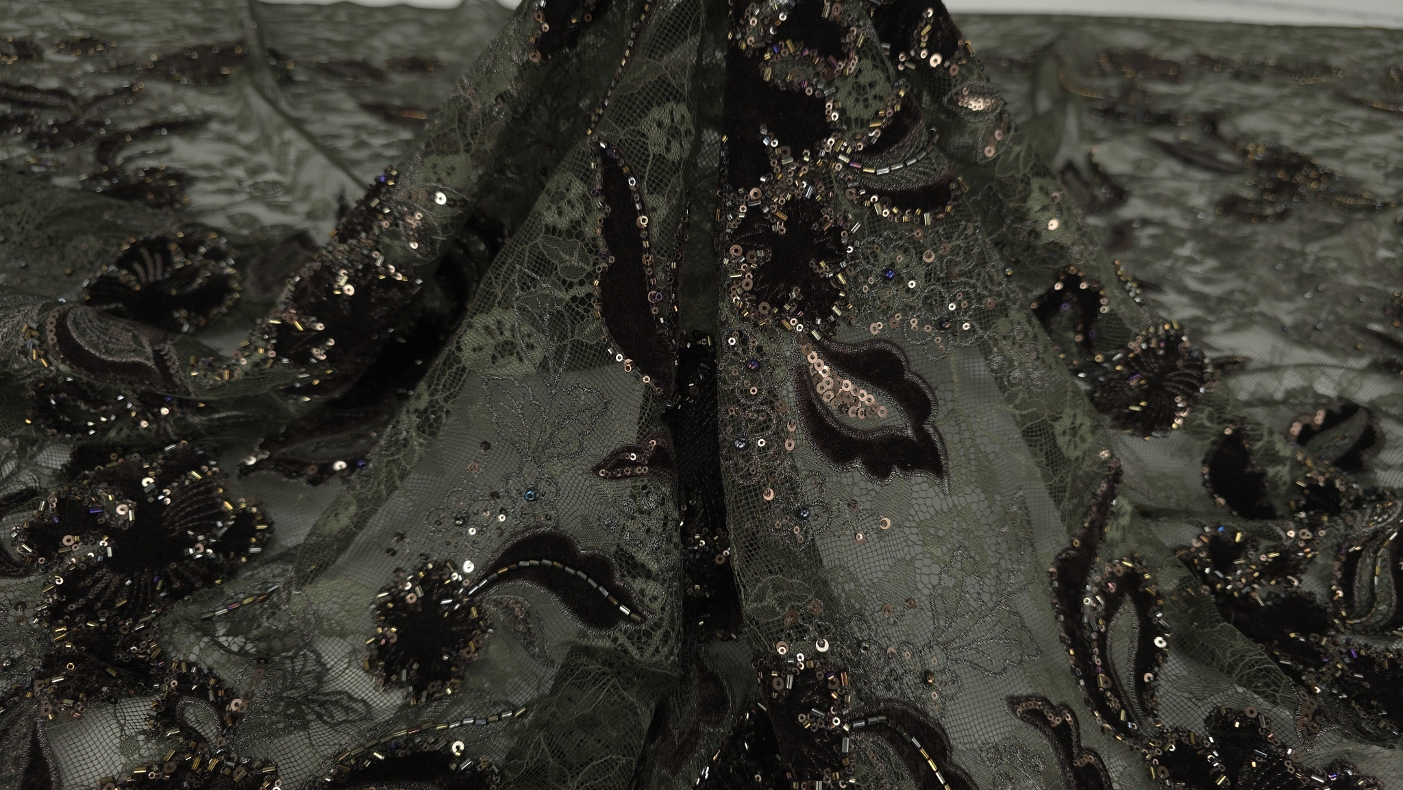 Falduri naturale ale materialului cu motive florale pe fond verde olive