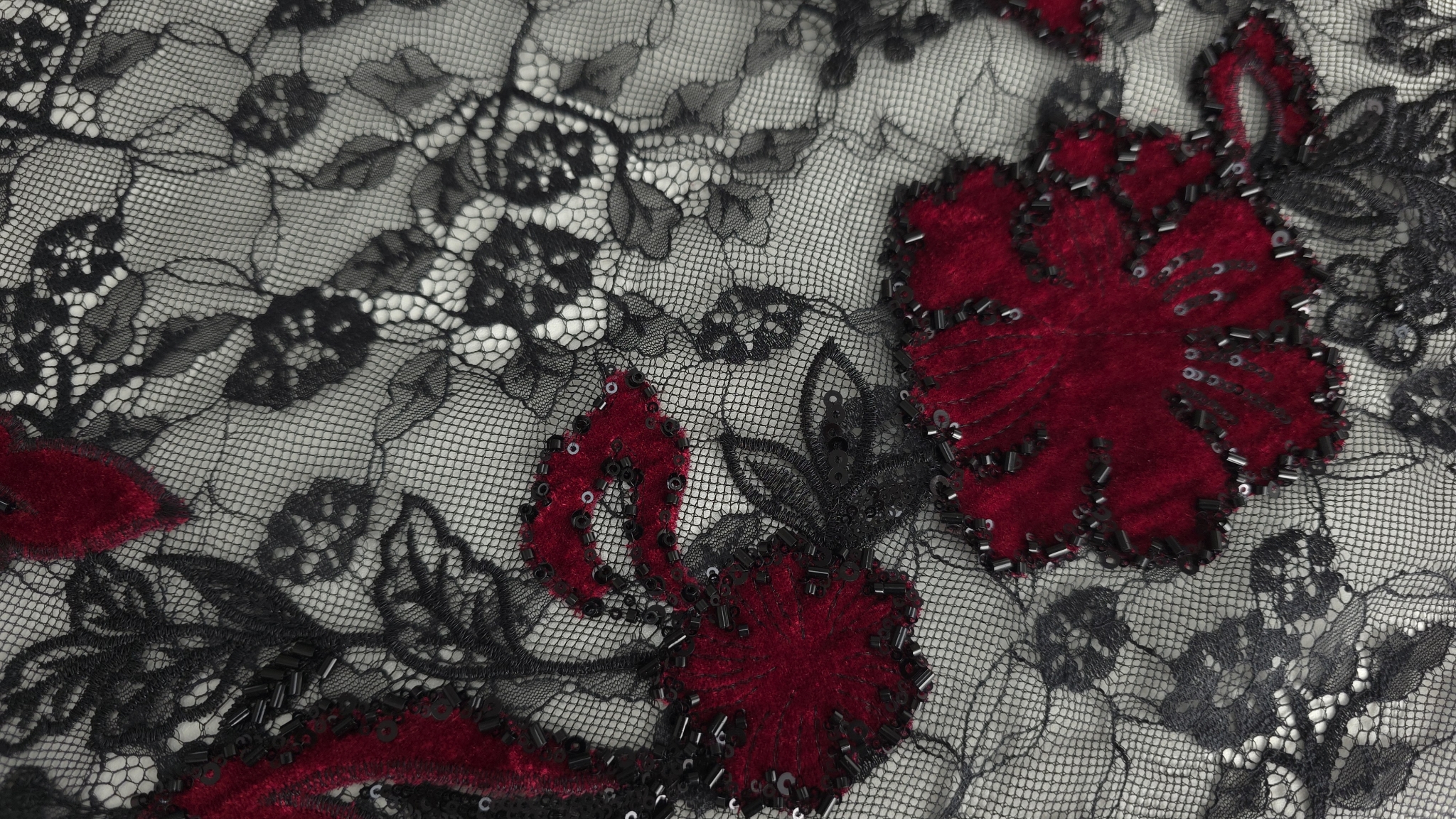 Falduri ridicate cu micropaiete strălucitoare pe conturul florilor din catifea