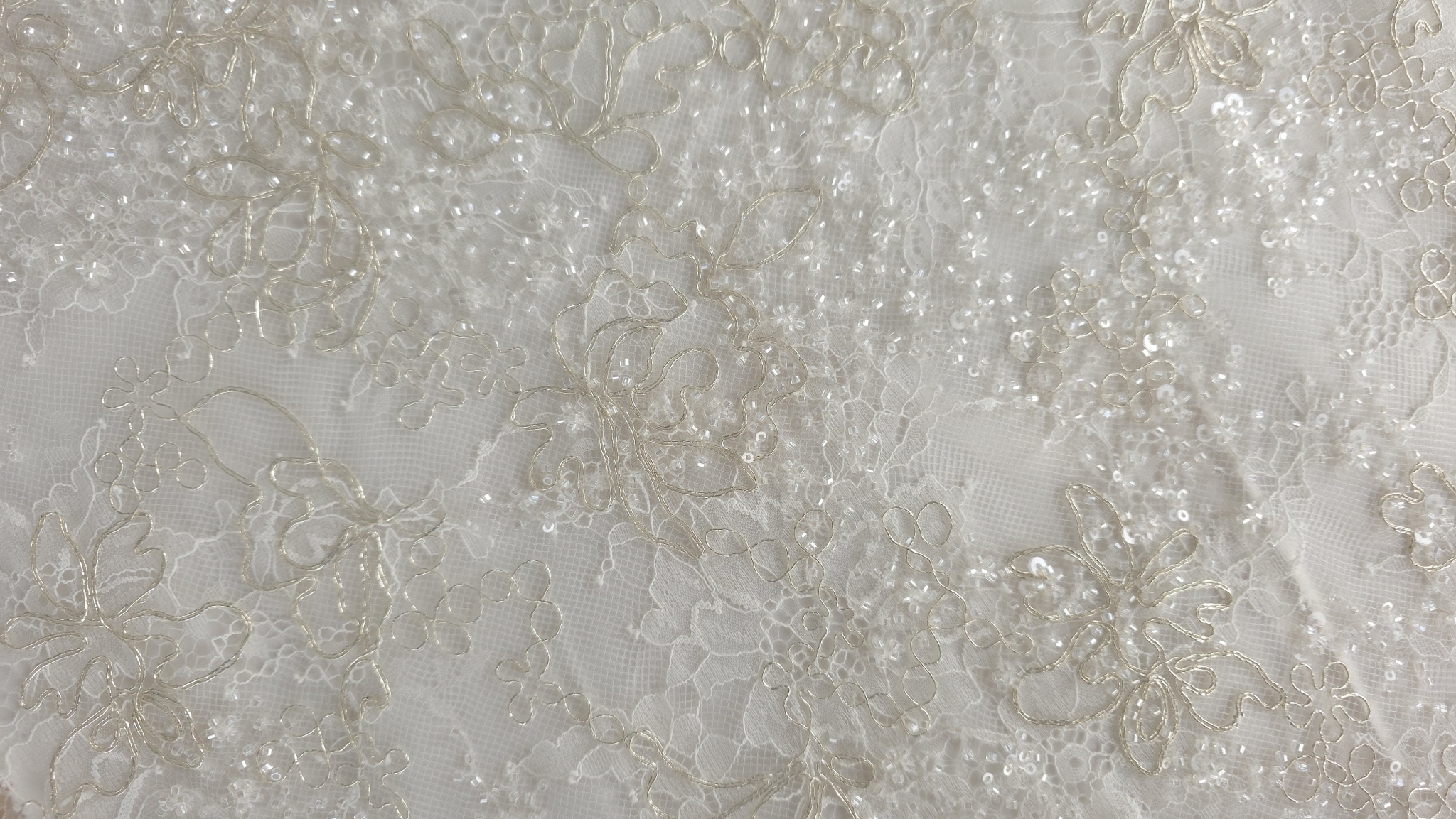 Flori conturate cu fir metalizat cald pe suprafață de tul fin