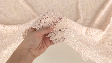 Mână ridicând materialul arătând transparența fondului de tul