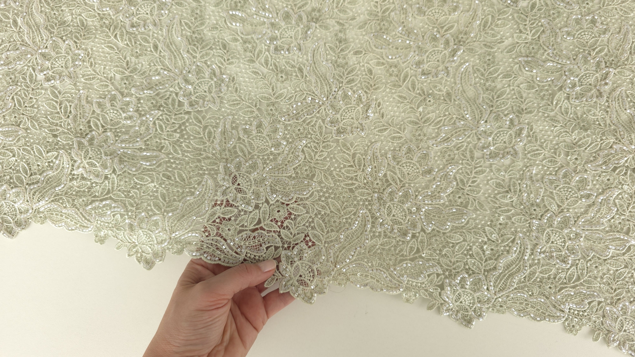 Mână ținând bordura decorativă evidențiind finisajul ondulat și flexibilitatea