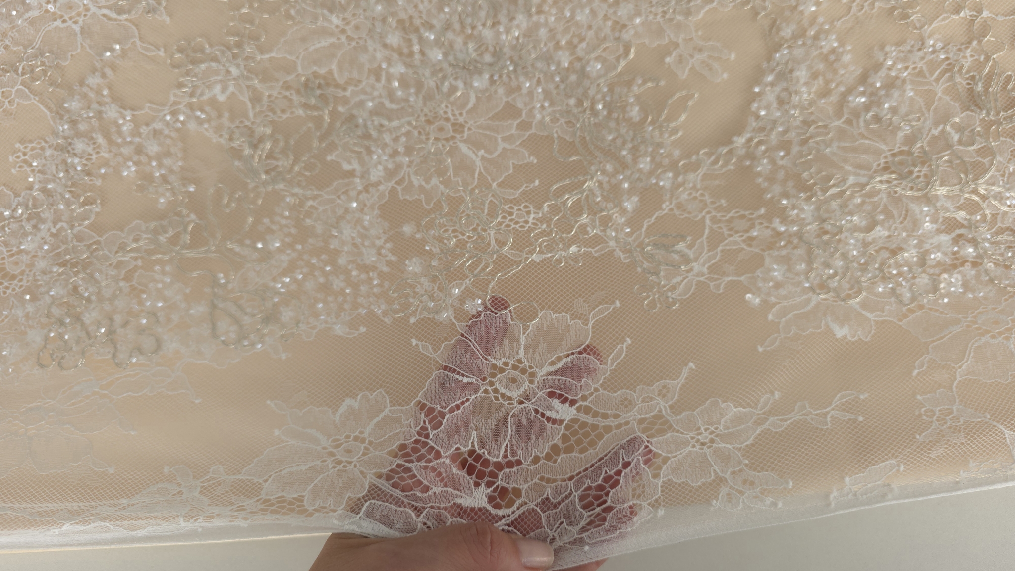 Margine de material floral întins peste degete pentru a arăta flexibilitatea