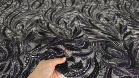 Marginea materialului cu motive care pornesc ascendent pe tulle verde