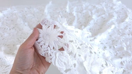 Material alb ținut în mână pentru a observa gradul de transparență