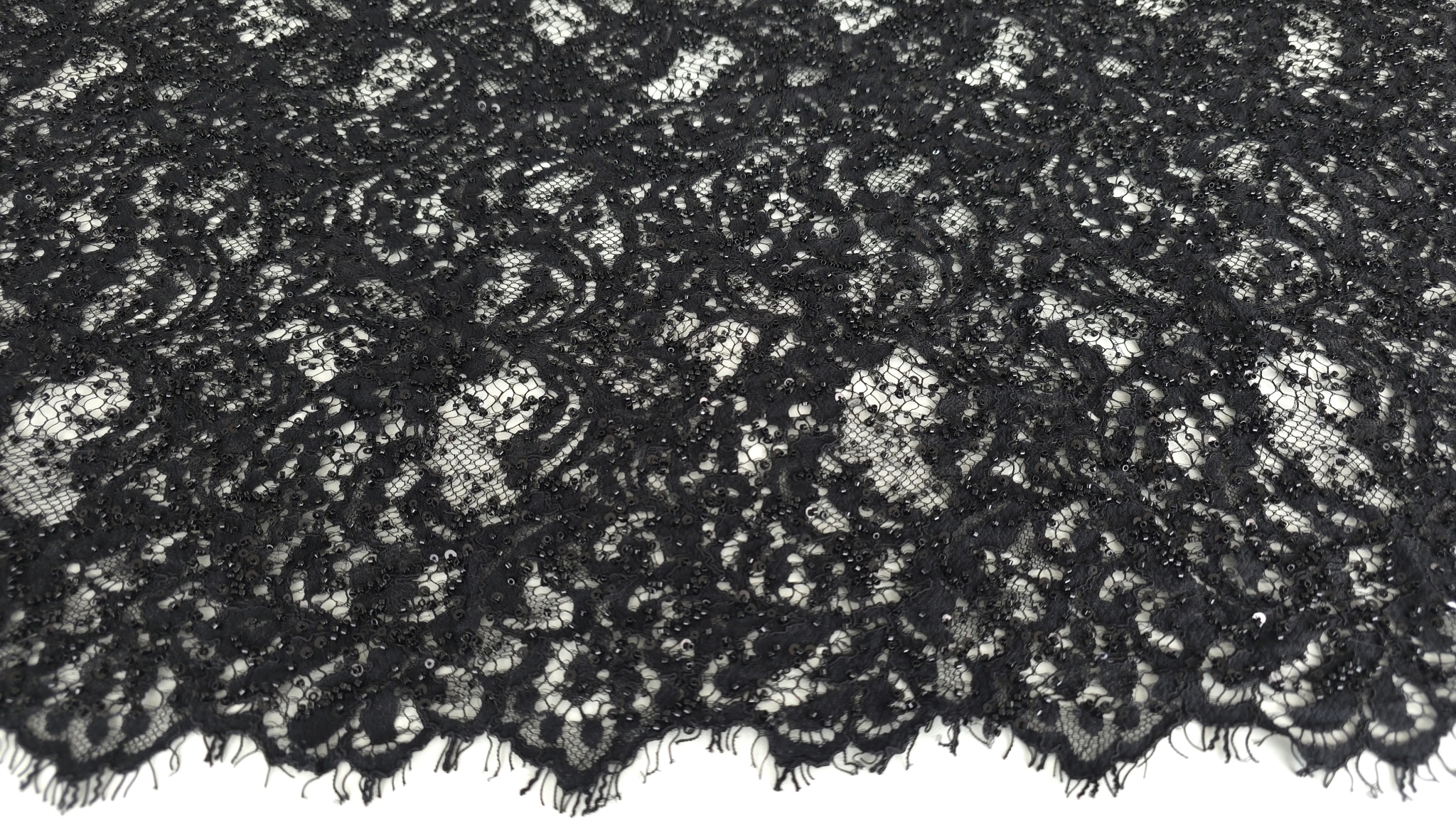 Material brodat negru cu aplicații strălucitoare fotografiat în lumină naturală