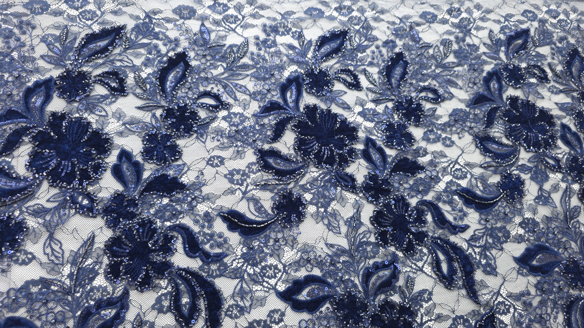 Material în falduri cu micropaiete vizibile pe motive florale